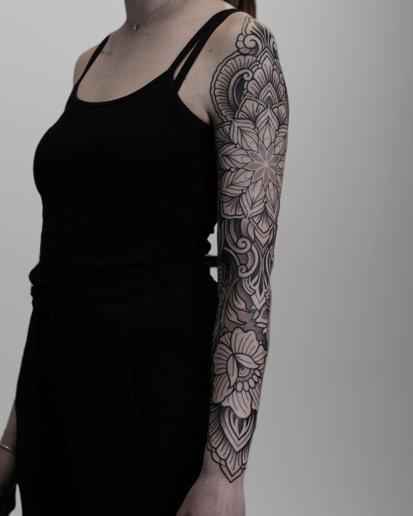 Mendhis inspired ornamental tattoo sleeve on the left arm of a girl. 